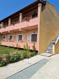 a pink building with stairs and flowers on it at lina studios in Mesongi