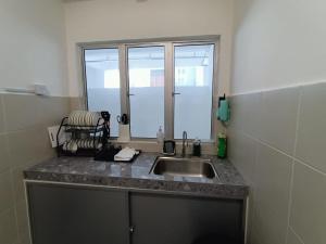 un comptoir de cuisine avec un évier et une fenêtre dans l'établissement Dream4 @ emerald avenue, à Brinchang