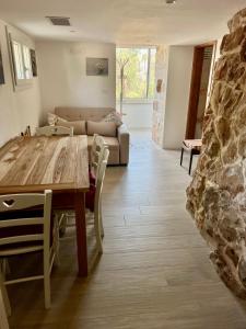 a living room with a wooden table and a couch at Trulli delle succulente in Capilungo