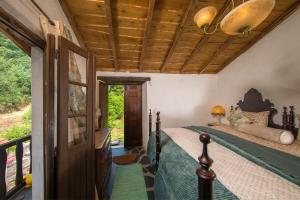 1 dormitorio con cama y techo de madera en Quintinha da Azenha AL, en Penacova
