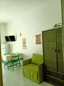 ein Wohnzimmer mit einem grünen Sofa und einem Tisch in der Unterkunft Il monolocale verde conchiglie e fiori in Ponza