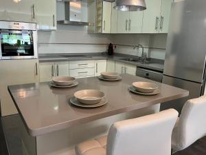 uma cozinha com uma mesa com quatro pratos em Puerto de la Cruz by Agüita Salada Suites em Puerto de la Cruz