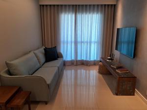 - un salon avec un canapé et une télévision dans l'établissement Cabo Frio com conforto e estilo!!!, à Cabo Frio