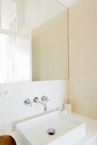 Baño blanco con lavabo y espejo en Lisboa Se, TravelingtoLisbon 271, en Lisboa