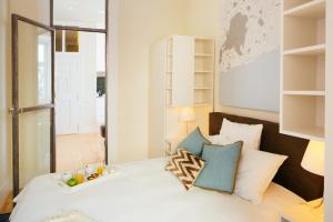 een slaapkamer met een wit bed met kussens bij Lisboa Se, TravelingtoLisbon 271 in Lissabon