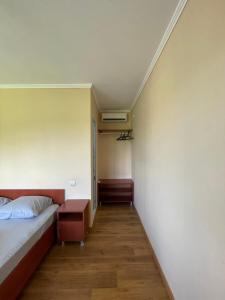 ein Schlafzimmer mit einem Bett und einem Nachttisch daneben in der Unterkunft Ldzaa House in Lidzava