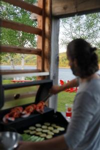 Una donna sta cucinando cibo su una griglia di Le 2800 du Parc a Shawinigan
