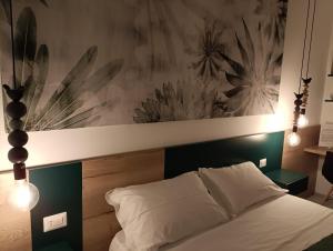a bedroom with a bed with a large painting on the wall at Corso Matteotti 162 - Affittacamere in Porto Recanati