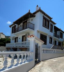 a large white house with a balcony at Villa Apostolis Studios in Skopelos Town