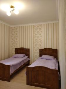 2 bedden in een kamer met 2 bedden, waarvan 1 tweepersoonsbed en 1 eenpersoonsbed. bij Hayk B&B (in Sanahin) in Alaverdi
