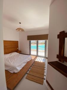 a bedroom with a bed and a view of the ocean at Swan Lake Crystal Lagoon View Chalet in Hurghada