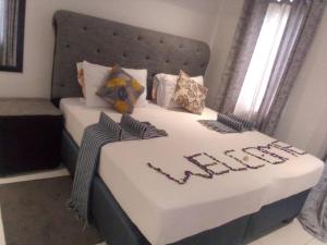 Una cama con la palabra fácil escrita en ella en Jayla Homestay en Maun