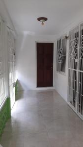 a hallway with a door in a room with white walls at Quiet Cottage in Residential Area in Montego Bay