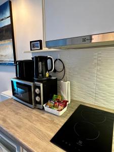 a kitchen counter with a microwave on a counter top at Grandblue Condominium#702 Seaview TopFloor MaePim Rayong in Mae Pim