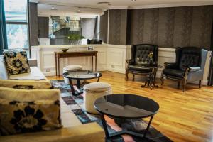 a living room with chairs and a couch and tables at Amérian Córdoba Park Hotel in Córdoba