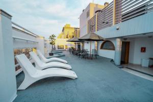 een rij witte stoelen en tafels op een gebouw bij Amérian Cordoba Park Hotel in Cordoba