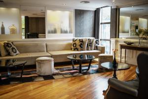a living room with a couch and two tables at Amérian Córdoba Park Hotel in Córdoba