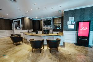 a salon with a bar with chairs in a room at Amérian Córdoba Park Hotel in Córdoba