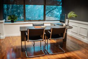 an office with a desk with a laptop and chairs at Amérian Córdoba Park Hotel in Córdoba