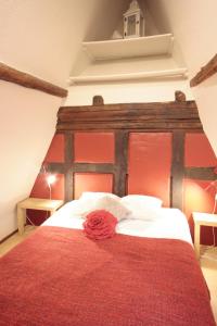 ein Bett mit einem roten Kopfteil mit einer roten Rose drauf. in der Unterkunft Appartement Zum Bären avec Parking in Colmar