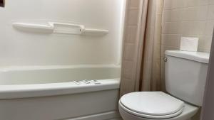 uma casa de banho com um WC e uma banheira em Bel-Air Motel em Sault Ste. Marie