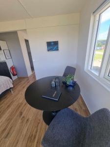 una habitación con mesa y 2 sillas y una habitación con cama en Hagi 2 Road 62 en Patreksfjörður