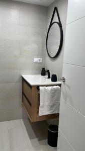 Baño blanco con lavabo y espejo en Apartamentos Numancia, en Garray