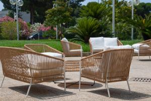 a group of rattan chairs and a table at Hotel Centrale in Sabaudia