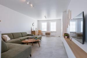 uma sala de estar com um sofá e uma mesa em Modern house JULIE with spacious garden and garage em Middelkerke