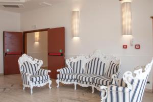 a group of white chairs sitting in a room at Hotel Centrale in Sabaudia