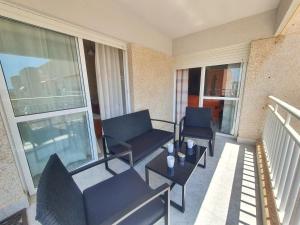 einen Balkon mit 2 Stühlen, einem Sofa und einem Tisch in der Unterkunft Vistas al mar con Aire Acondicionado y Parking - by Aloha Palma in Águilas