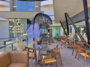 a lobby with tables and chairs and a chandelier at pie de playa y con vista al mar by G P S rentas in Mazatlán