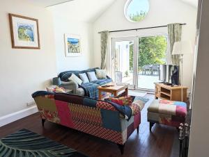 a living room with a couch and a tv at Beach Front House with Stunning Sea Views and Free Use of a Local Indoor Pool in Talland