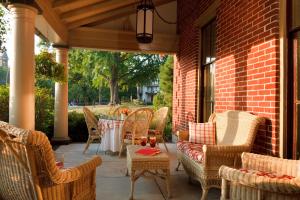 a patio with wicker chairs and a table on a brick building at The Sayre Mansion in Bethlehem