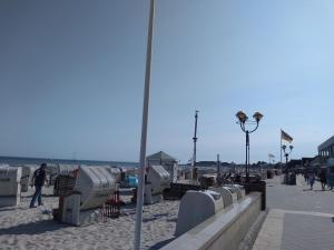 a beach with a pole and people walking on the beach at FeWo 3 mit Terrasse, Box-Bett, kl extra Zi mit Einzelbett, Tresor in Dahme