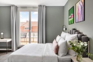 um quarto com uma cama branca e uma janela em numa I Boxer Rooms and Apartments em Berlim