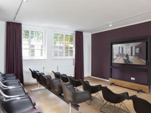 sala de estar con sillas y TV de pantalla plana en Discover Langeoog Comfortable apartment with SPA and pool en Langeoog