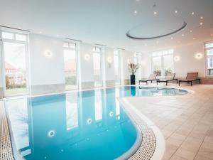 a swimming pool in a house with windows at Discover Langeoog Comfortable apartment with SPA and pool in Langeoog