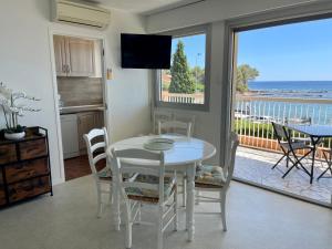 a kitchen and dining room with a table and a view of the ocean at Appartement 4 pers Front de Mer - 10m de la Plage in Saint-Raphaël +31 photos