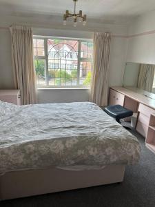 Schlafzimmer mit einem Bett, einem Schreibtisch und einem Fenster in der Unterkunft Le Royal Residence 7 in London