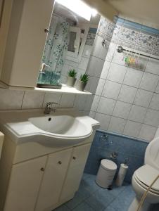 a bathroom with a sink and a toilet at PERIGIALI APARTMENT in Kavála