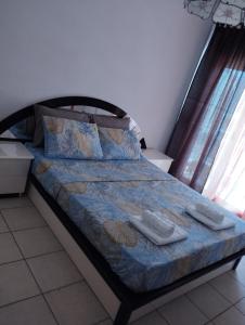 Una cama en una habitación con dos toallas. en PERIGIALI APARTMENT, en Kavala