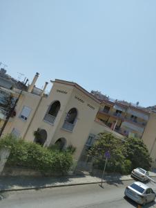 un edificio con coches estacionados frente a él en PERIGIALI APARTMENT, en Kavala
