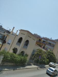 a building with cars parked in front of it at PERIGIALI APARTMENT in Kavála