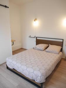 a large bed in a room with a white wall at Le Laurenti in Quérigut