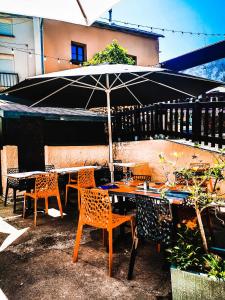 een patio met tafels en stoelen en een parasol bij Le Laurenti in Quérigut