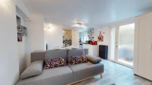 a living room with a gray couch and a kitchen at Studio avec parking Rue de la Semm in Colmar