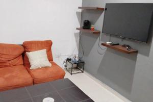 uma sala de estar com um sofá e uma televisão de ecrã plano em Casa Privada San Pedro em Kanasín