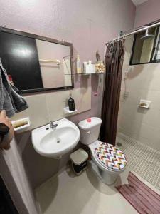 uma casa de banho com um lavatório, um WC e um espelho. em Casa Privada San Pedro em Kanasín