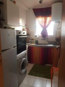 丹吉爾的住宿－Appartement Riad Tanger，厨房配有洗衣机和窗户。